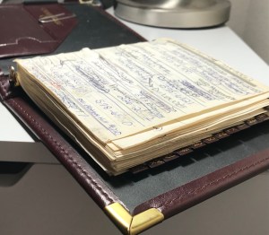 spiral-bound address book showing many entries crossed out